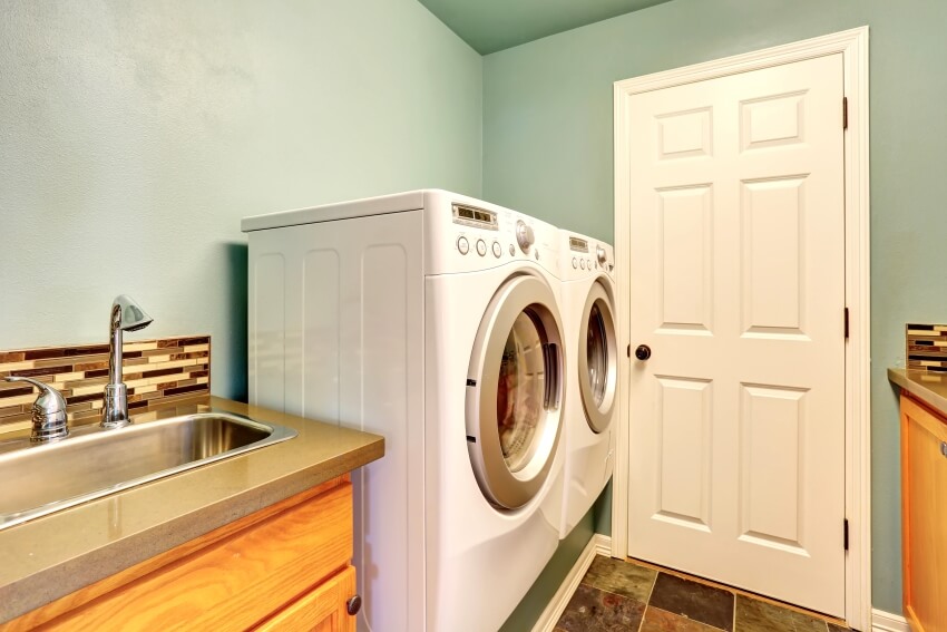 Mint laundry room with glass tile backsplash, and stainless steel sink and faucet