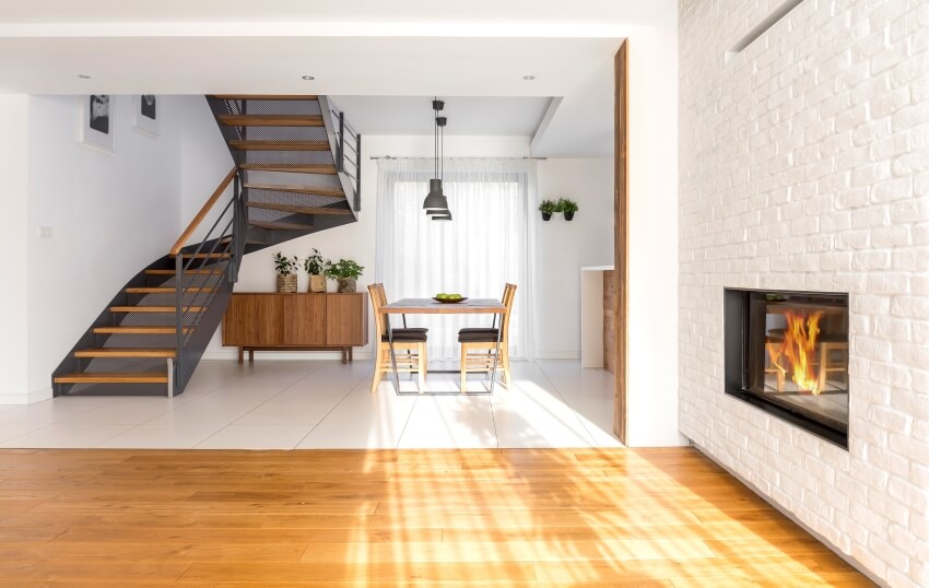 Modern apartment with staircase, fireplace, brick wall, and uneven floor