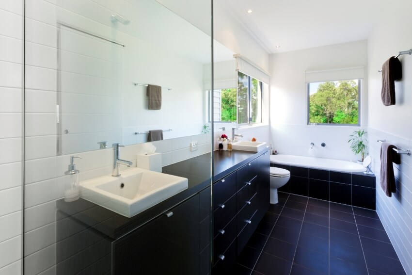 Modern bathroom with black tile floor, white walls, and painted countertops