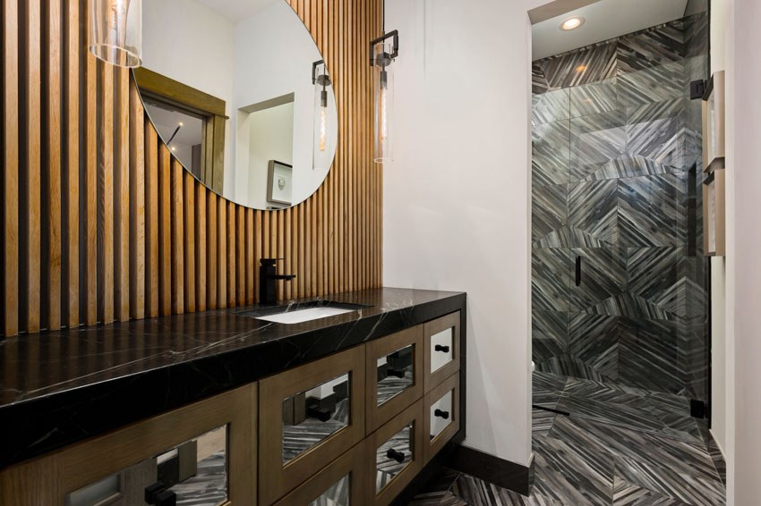 Modern bathroom with mirror wood slat, backsplash, cabinets, and soapstone countertop