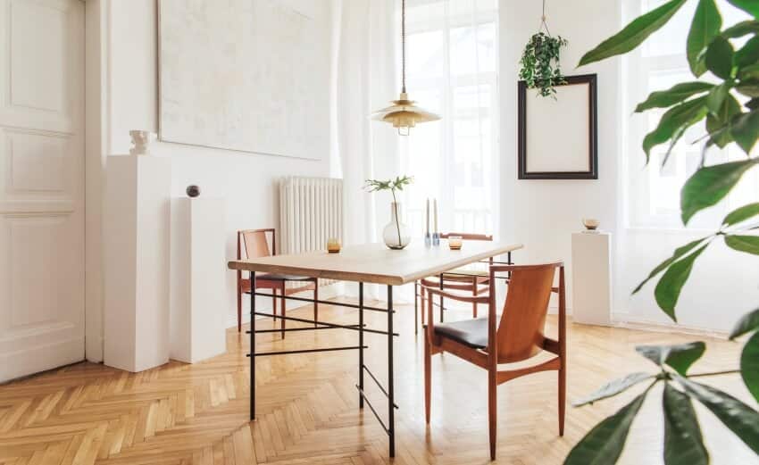 Modern dining room with parquet floor and pendant lights above dining table with chairs