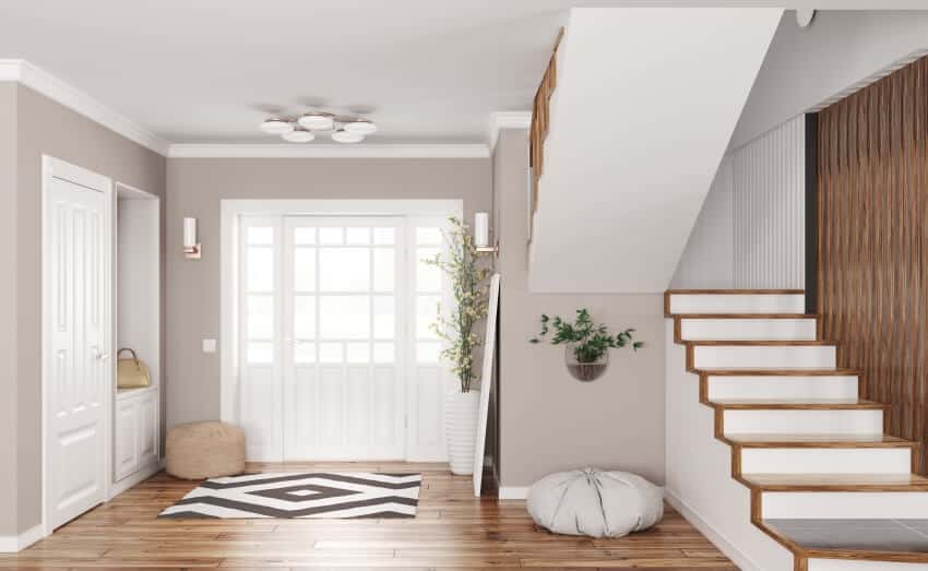 Modern entrance hall with staircase, poufs, hardwood floor, and ceiling and wall lights