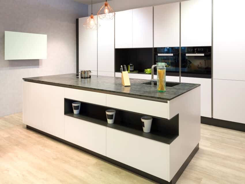 Modern flat white kitchen with pendant lights, and island with recessed shelf and grey countertop
