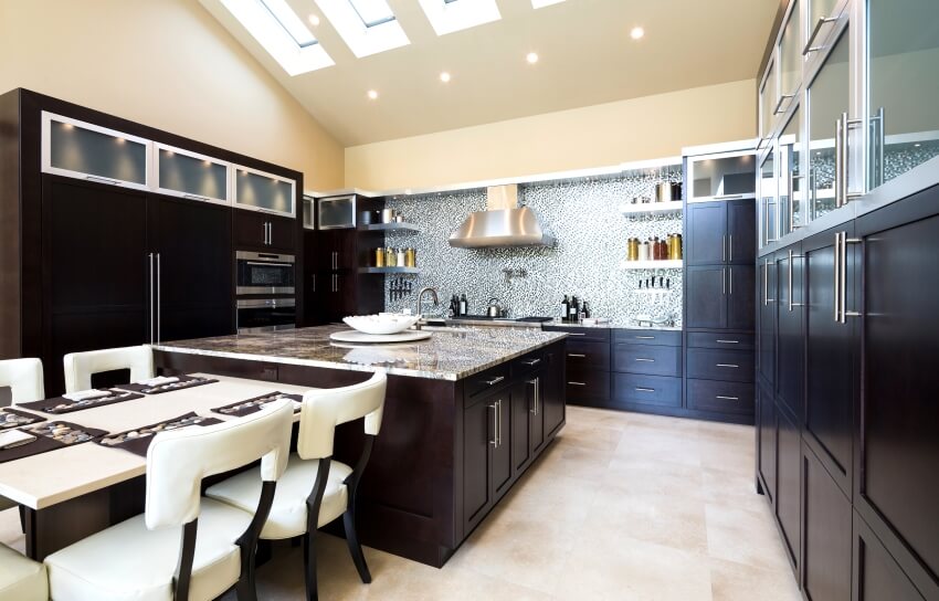 Modern kitchen with dark cabinets, skylight windows, mosaic tile backsplash, and breakfast table