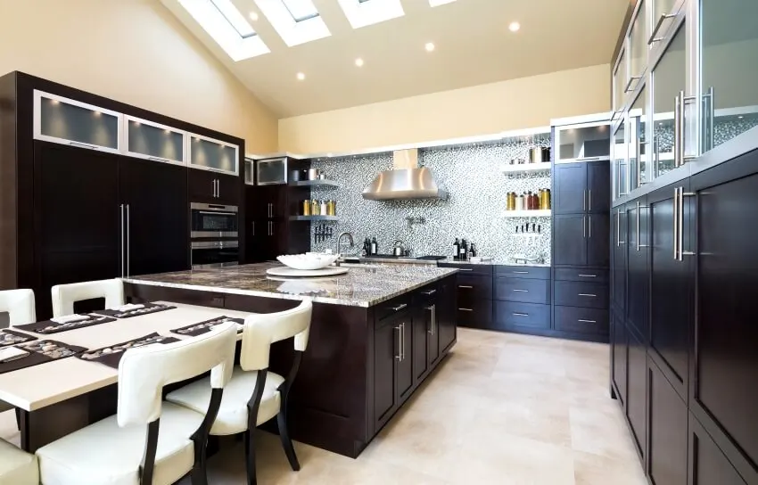 Kitchen with dark cabinets, skylight windows and mosaic tile backsplash