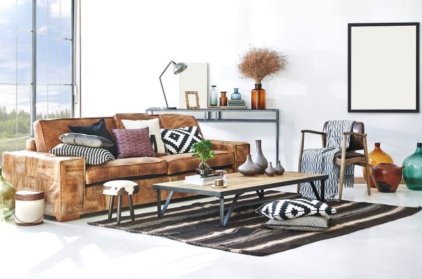 Modern decorated room with brown sofa with pillows, coffee table, and panoramic windows