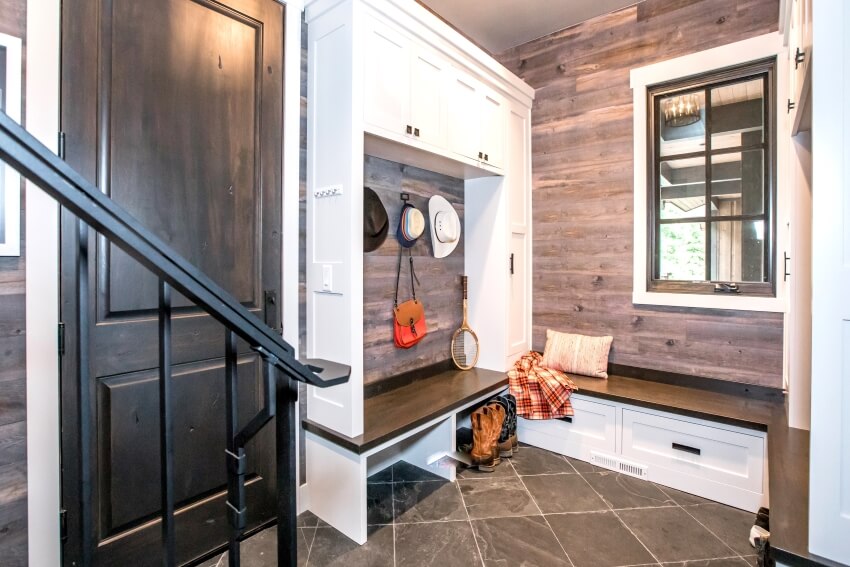 Mudroom with tile floor, white cabinets, and wooden bench