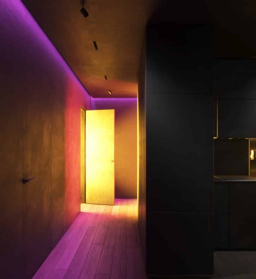 Multi-colored night lighting in the hallway of an apartment with hardwood floor