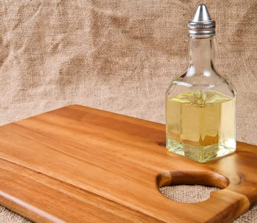 Olive oil in bottle on acacia wood board