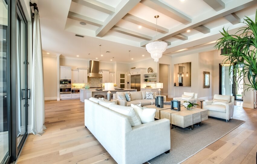 Open floor plan home with wood floor, ceiling beams, and white furniture