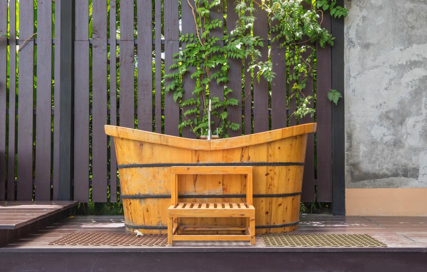 Outdoor area with Japanese style tub, and wood fence