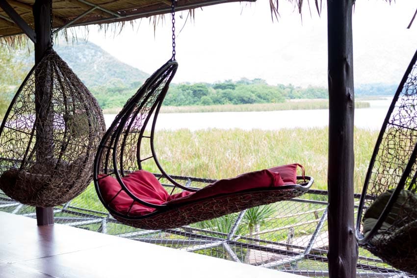 Outdoor deck with hanging egg chair hammock, and cushion