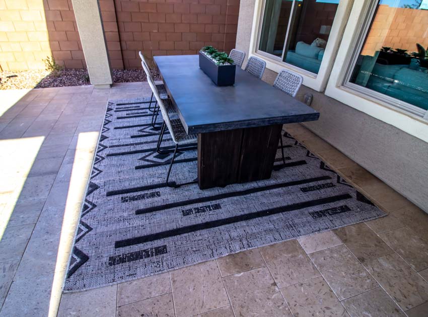 Patio with outdoor rug, table, chairs, and stone tile flooring