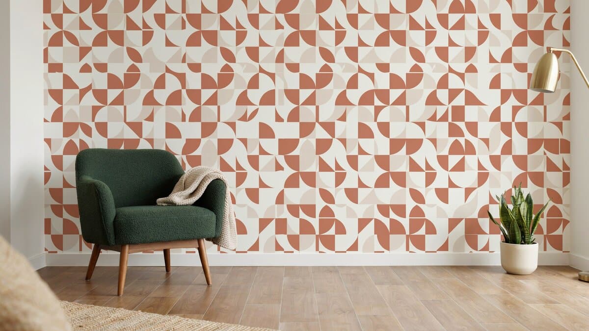 Terracotta geometric peel and stick wallpaper behind a green accent chair