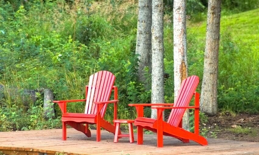 Red adirondack chairs on a wooden deck