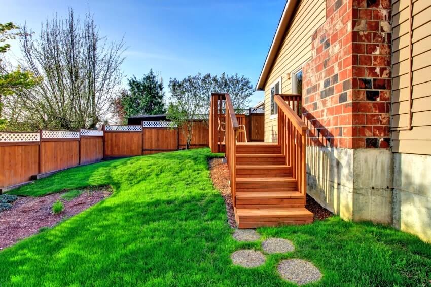 Redwood fenced backyard of a house with walkout deck