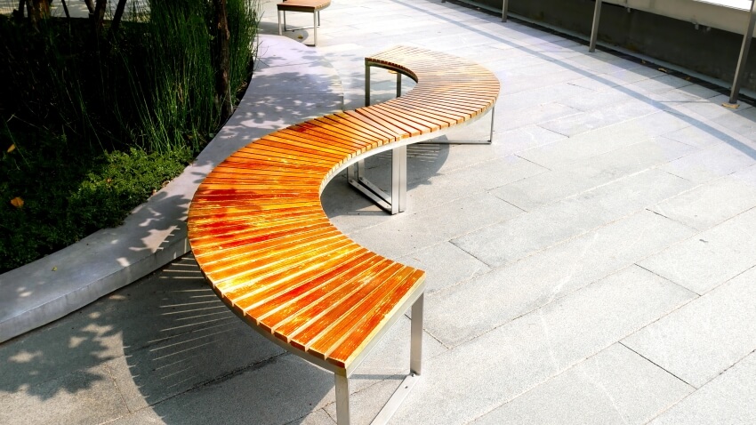 S-curved bench made of wooden planks and welded steel frames