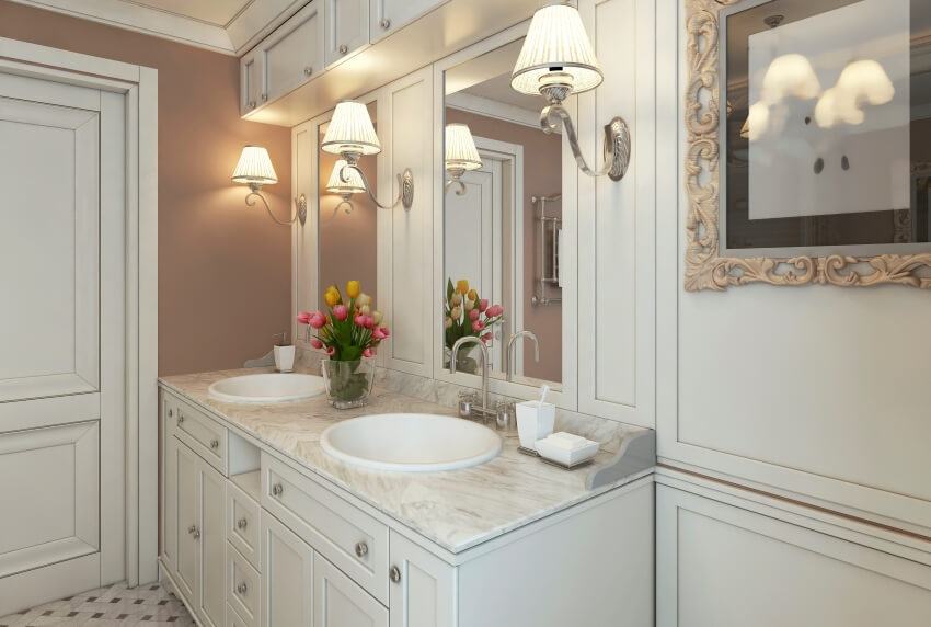 Sconce lights and white vanity with quartzite countertop in a classic bathroom