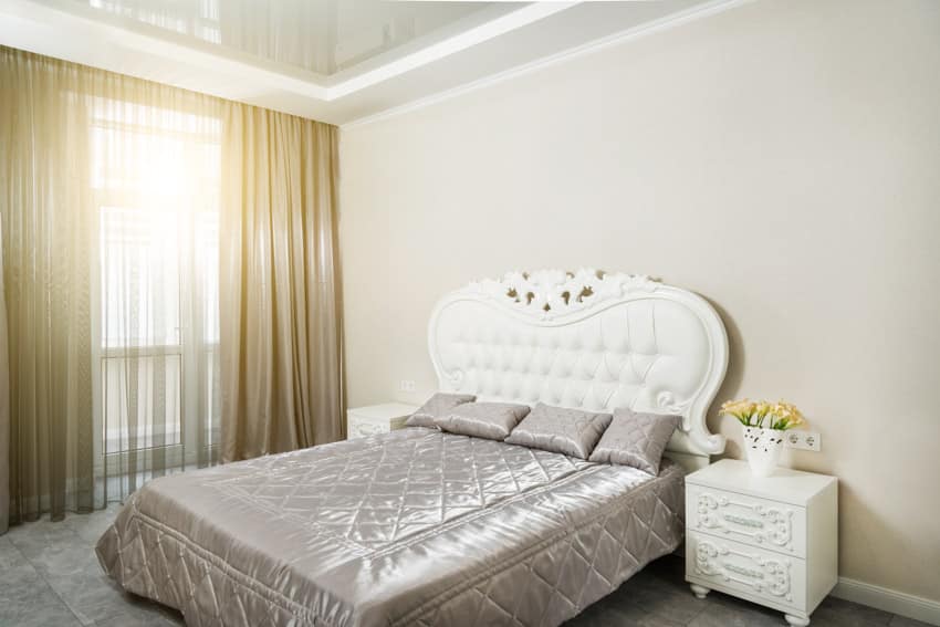 Bedroom with shiny comforter and white headboard