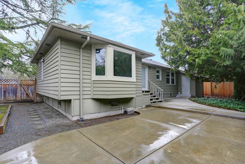 Simple house with siding, bay window, and sealed driveway