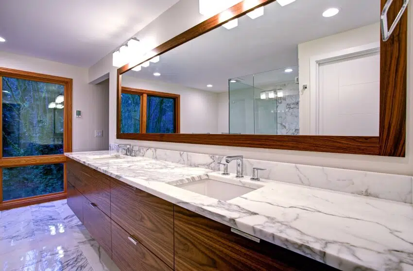 Sleek bathroom features double vanity with Calacatta marble countertops and undermount sinks