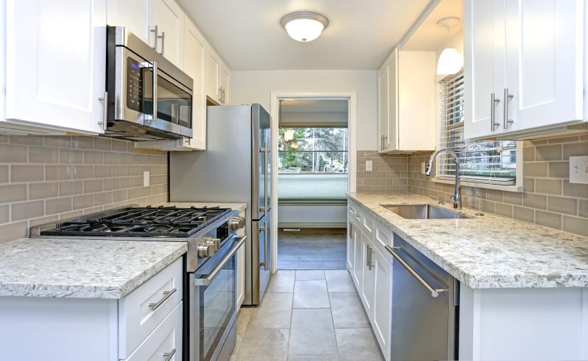 Small kitchen with white shaker cabinets, quartz countertops, and subway tile backsplash