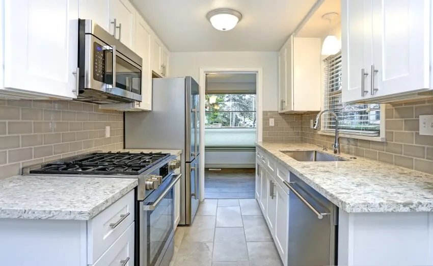 Kitchen with white shaker cabinets, quartz countertops, and subway tile backsplash