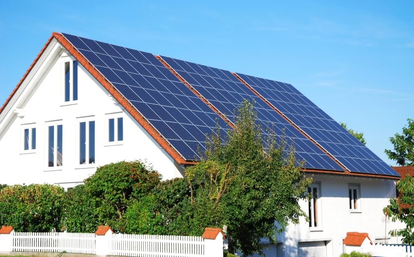 Solar panels on the roof of a white big house