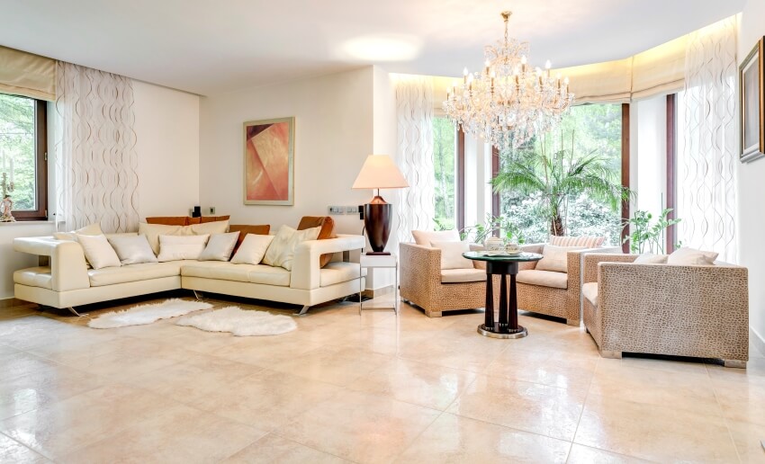 Spacious living room with sofa and armchairs, chandelier, and polished limestone tiles