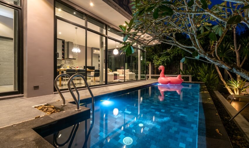 Swimming pool of a house with a pink swan floatie and LED lights