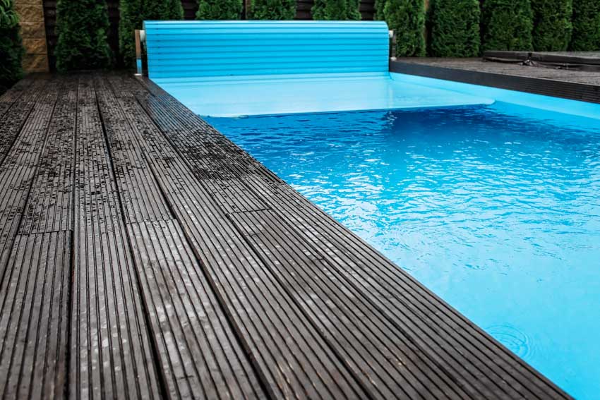 Swimming pool with covering mechanism, and wood deck