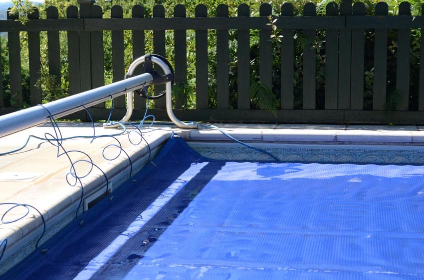 Swimming pool with covering mechanism, coping, and liner