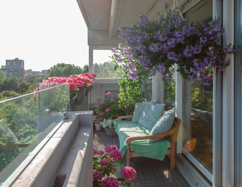 Terrace garden with cushioned couch, potted plants, and flowers