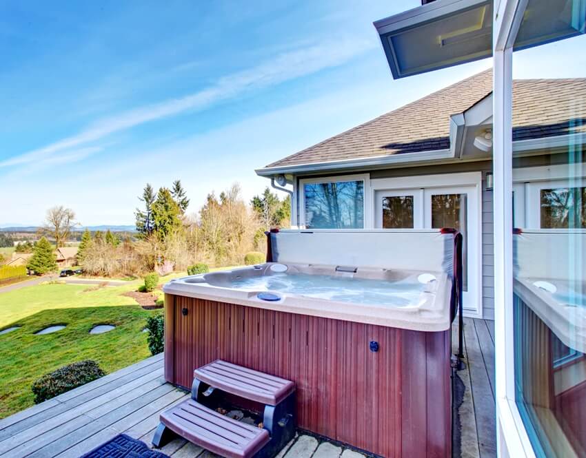 Traditional back deck with a beautiful landscape, tall windows and a hot tub with relaxing nature view