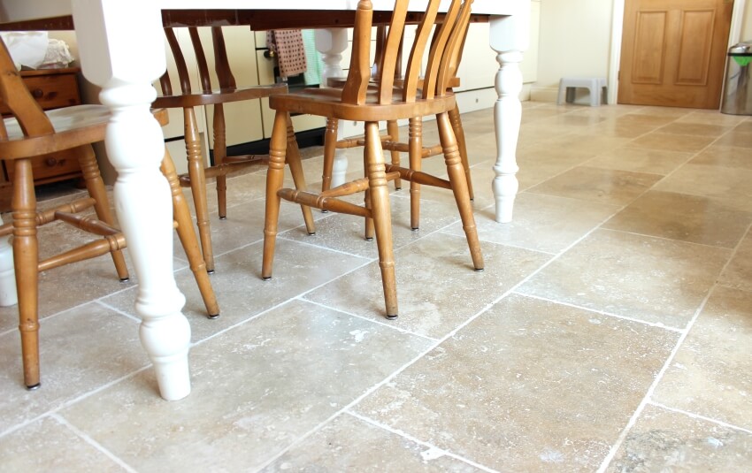 Travertine tile floor, white painted pine table, and beech chairs in a kitchen