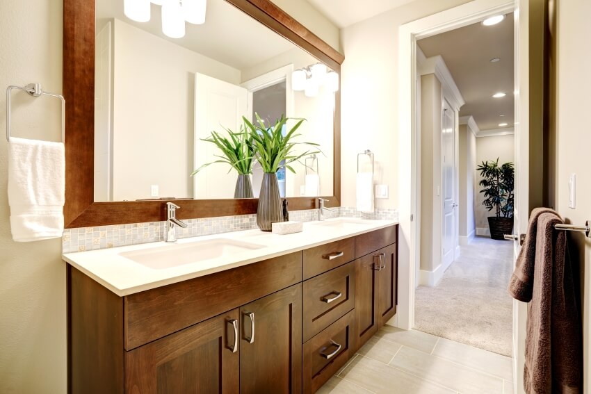 White and clean bathroom design with dark wood vanity cabinets and sconce lights