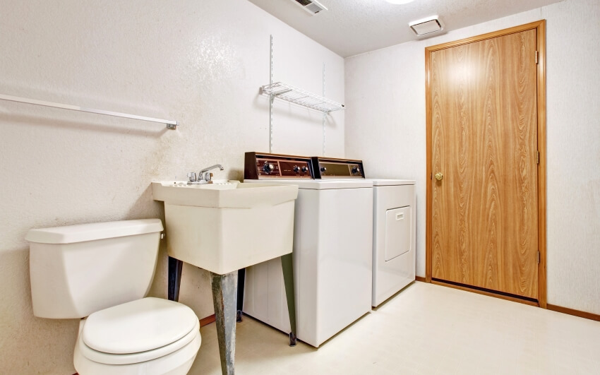 White simple laundry room interior with utility sink and toilet