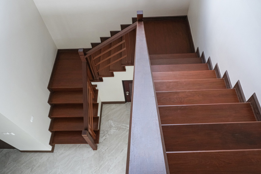 Wooden staircase leading to basement with painted floor