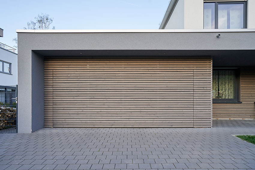 Modern house with hidden garage door with concrete pavers driveway