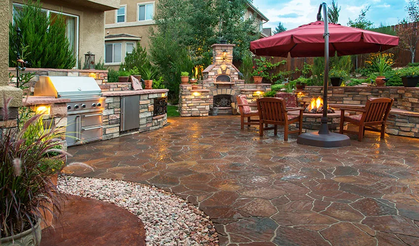 Outdoor patio kitchen with stone pavers flooring round fire pit fireplace