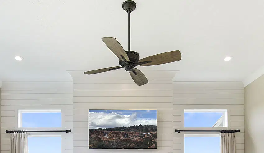 Wooden blade fan with shiplap wall and curtain rod