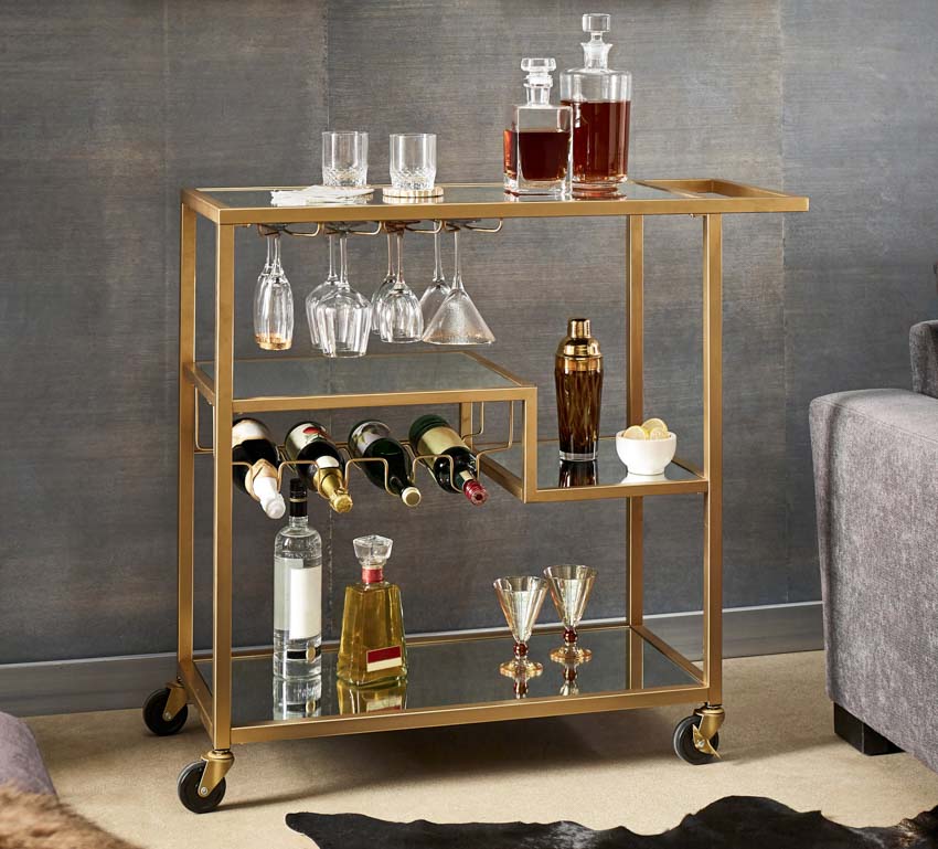 A mobile cart filled with drinks and glasses as a nightstand alternative