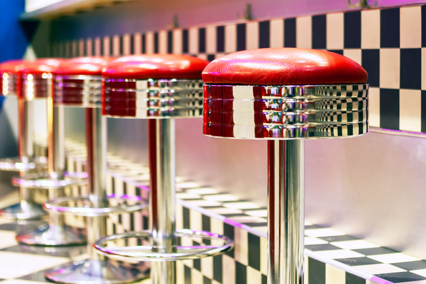 A series of chrome finished stools with red cushioning