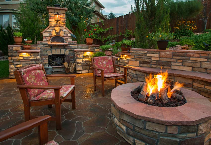 Backyard patio with firepit, chairs and stacked stone benches