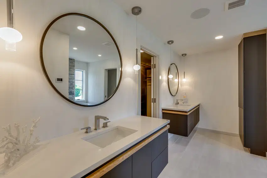 Bathroom vanity with limestone floor, mirror, countertop, sink, floating vanity, and wall mounted lights