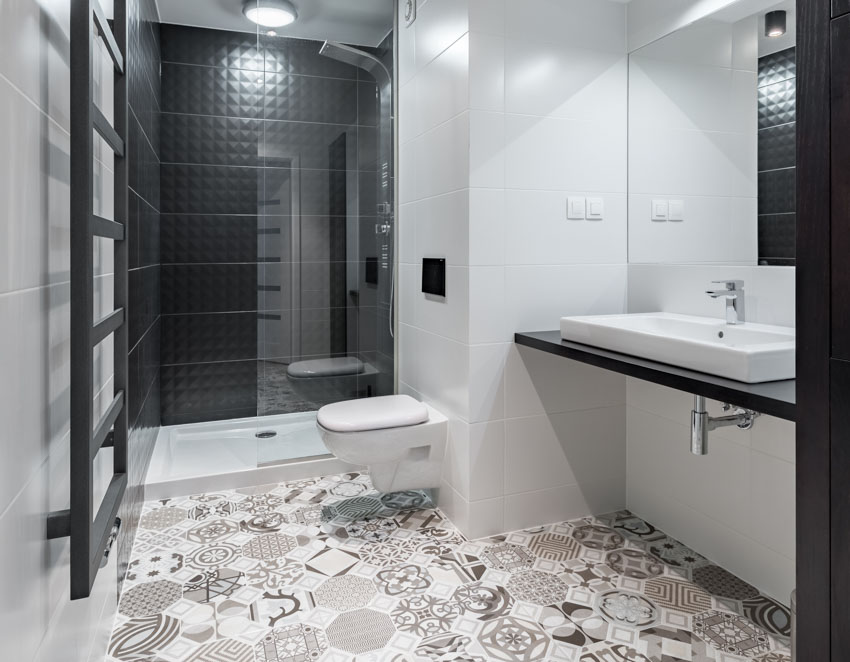 Bathroom waterproof peel and stick floor tiles, shower area, glass door, toilet, floating countertop, and sink mirror