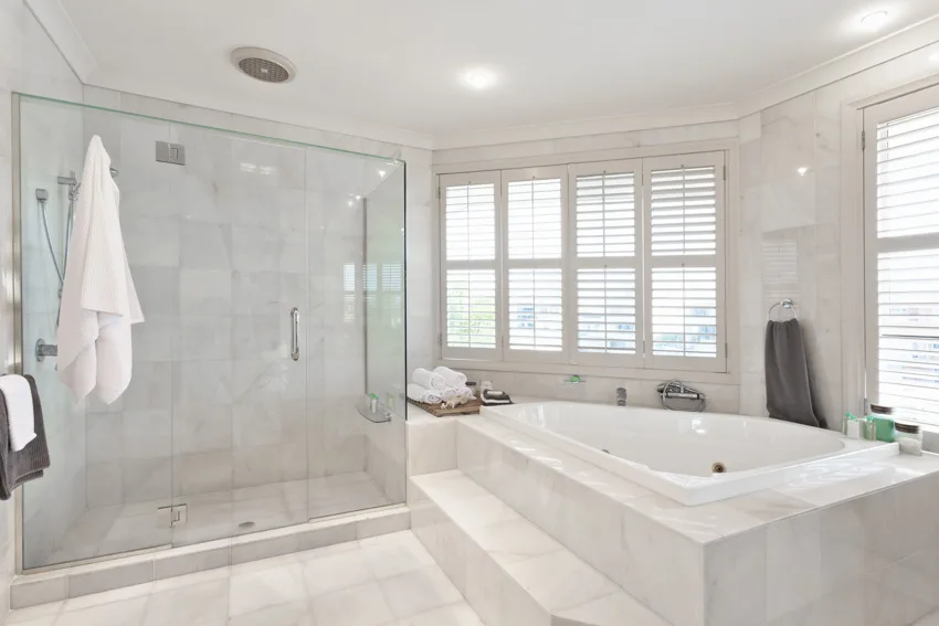 Bathroom with Carrara marble shower, glass divider, tub, and windows