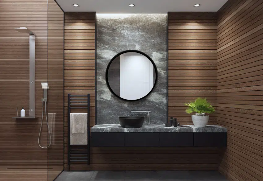 Bathroom with glass door, shower area, modern showerhead, horizontal wood slat walls, black countertop, and mirror