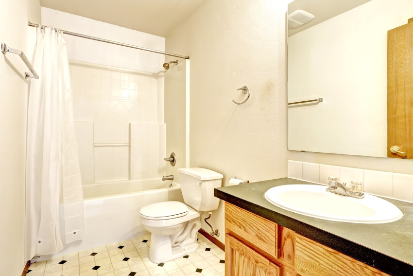 Bathroom with linoleum floor, wooden cabinet with mirror, and white bath tub with curtains