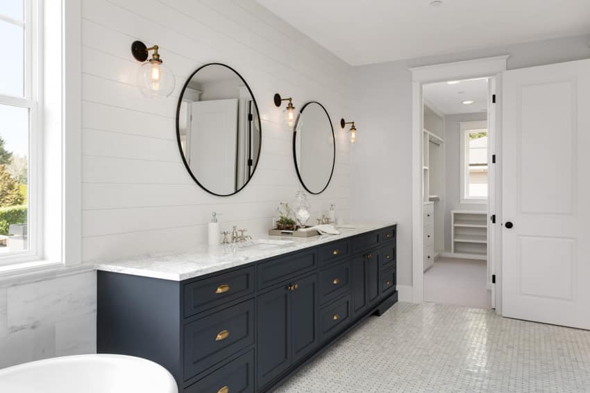 Vanity with bathroom shiplap backsplash, round mirrors, countertop, cabinets, and widows